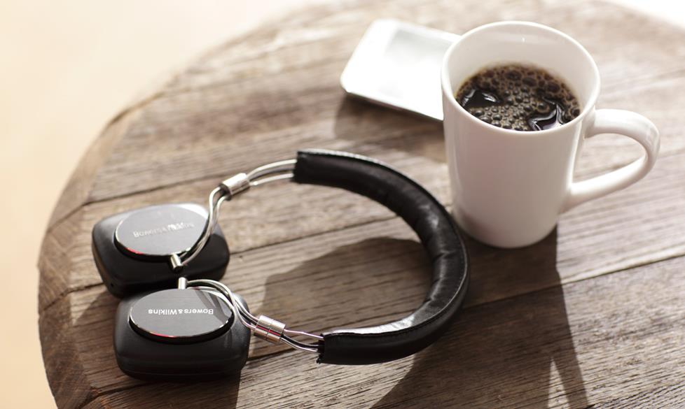 Headphones next to a coffee cup