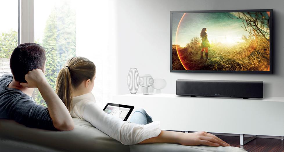 photo of a couple watching TV, listening to a Yamaha YSP-5600 Digital Sound Projector