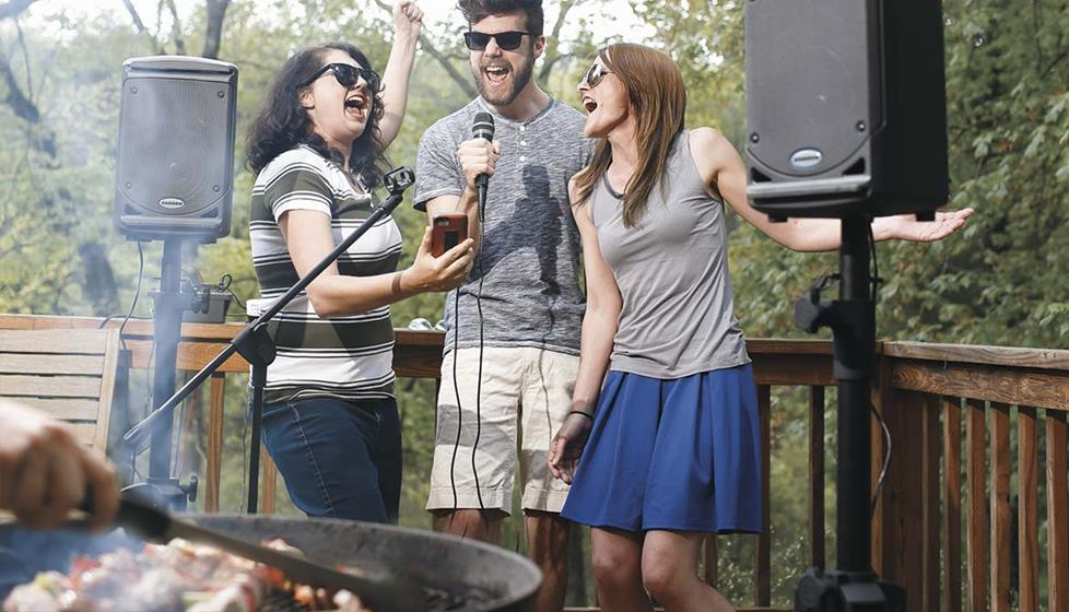 people singing outide on a deck with the Singtrix® Home karaoke system