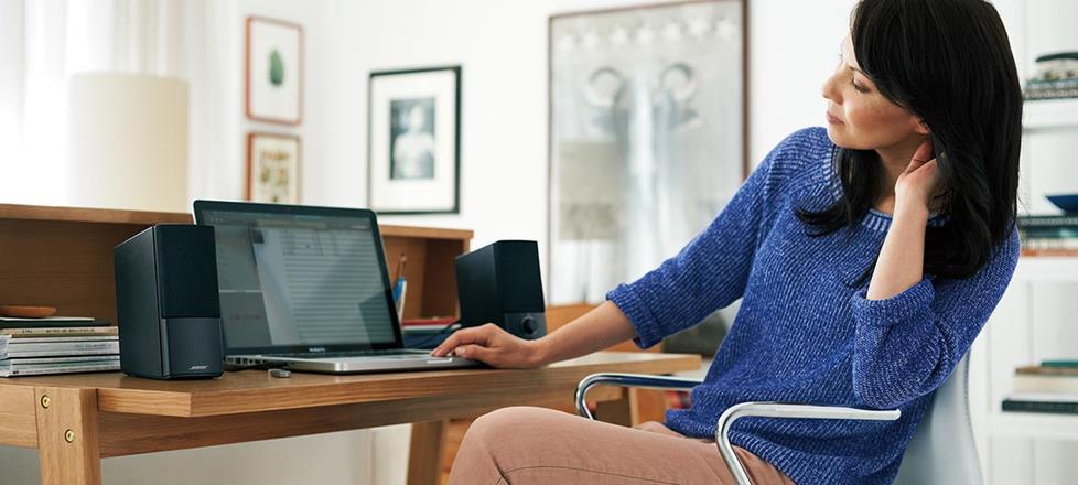 Woman listening to Bose® Companion® 2 Series III multimedia speaker system