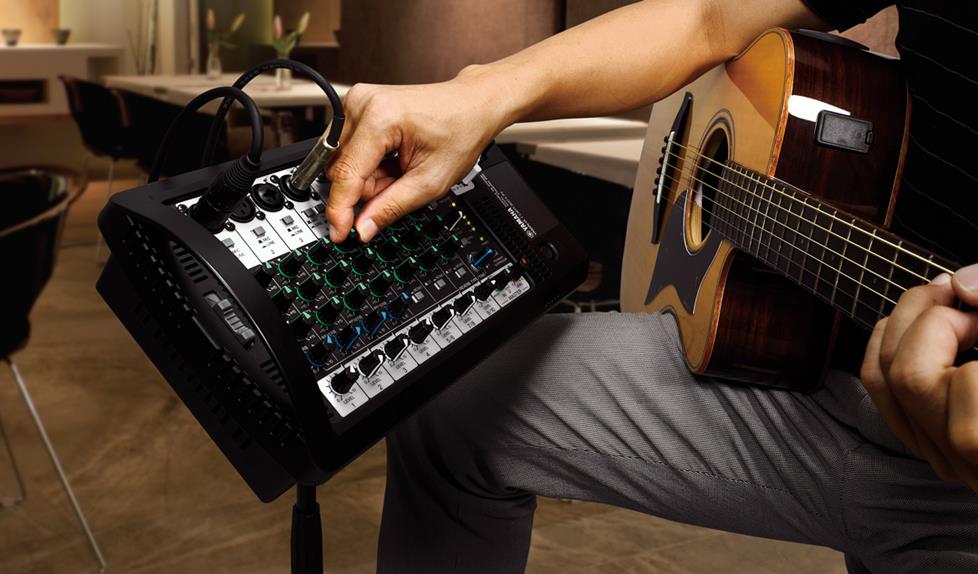 Guitar player adjusting portable PA mixer