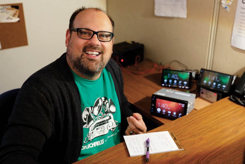 Dominic DeVito at his desk with three Sony touchscreen stereos