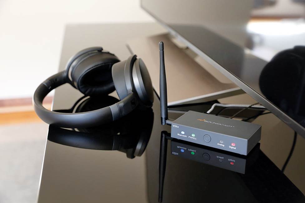Bluetooth transmitter with headphones next to TV