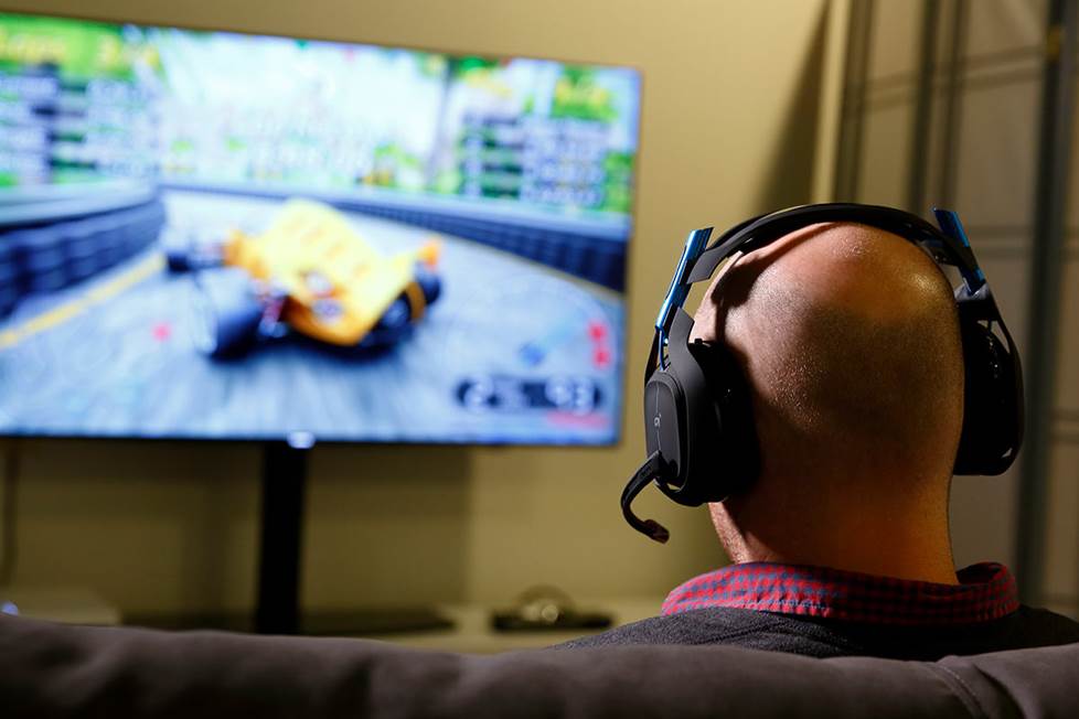 Man playing video games on couch with gaming headset