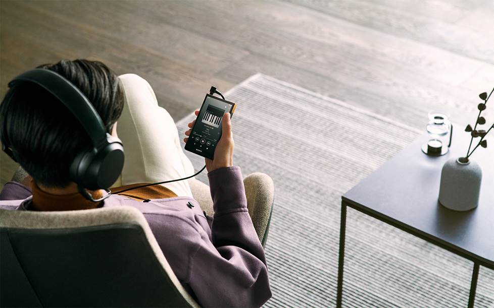 Person listening to music on portable high-res music player.