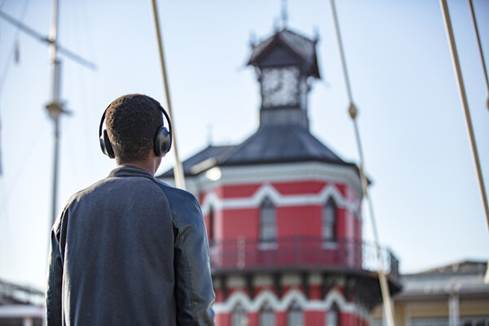 Man wearing Bose Noise Cancelling Headphones 700 and looking at building
