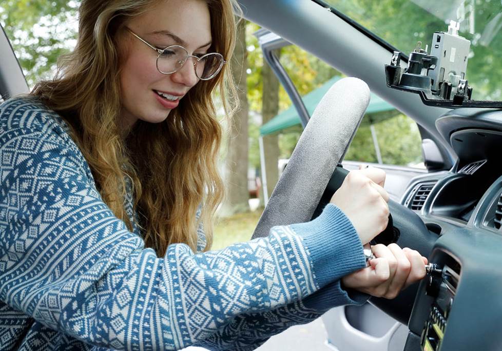 Elizabeth removes the factory radio from her Toyota Camry.