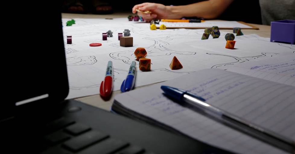 a laptop with game pieces on a table