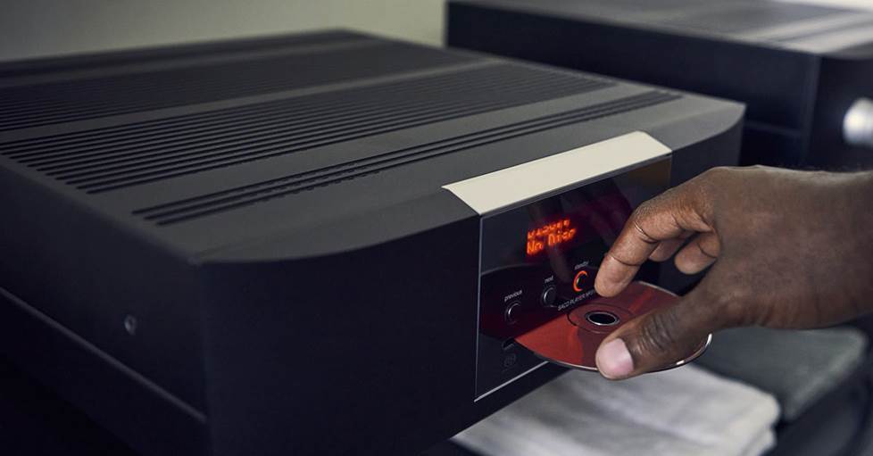 a hand loading a CD into a Mark Levinson No.5101 CD player