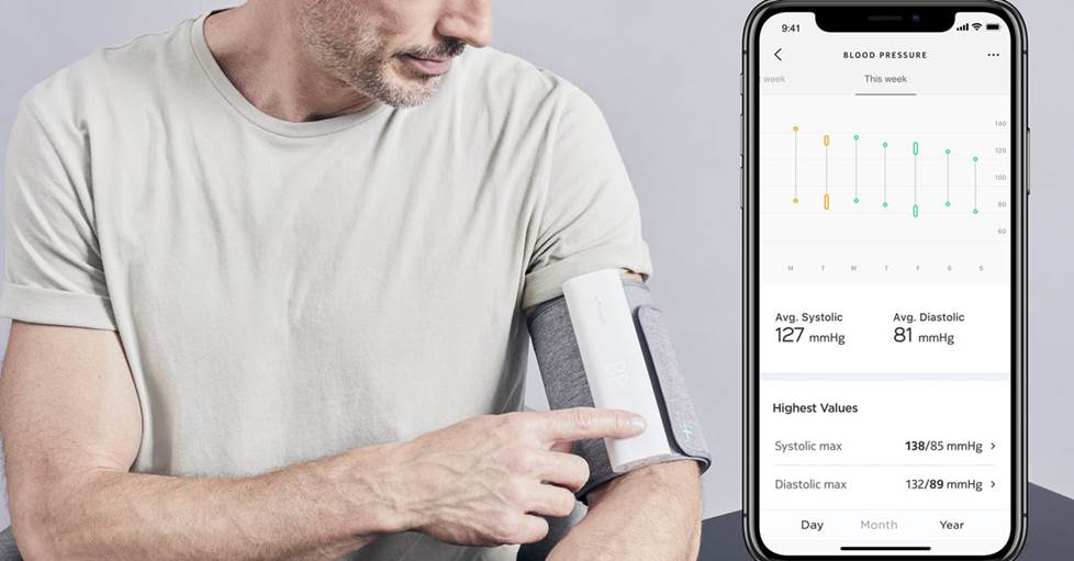 A man using Withings BPM Connect Smart blood pressure monitor and showing the app screen