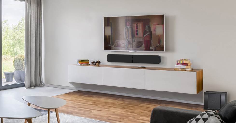 Bluesound PULSE SOUNDBAR+ Streaming sound bar mounted on a wall in a living room