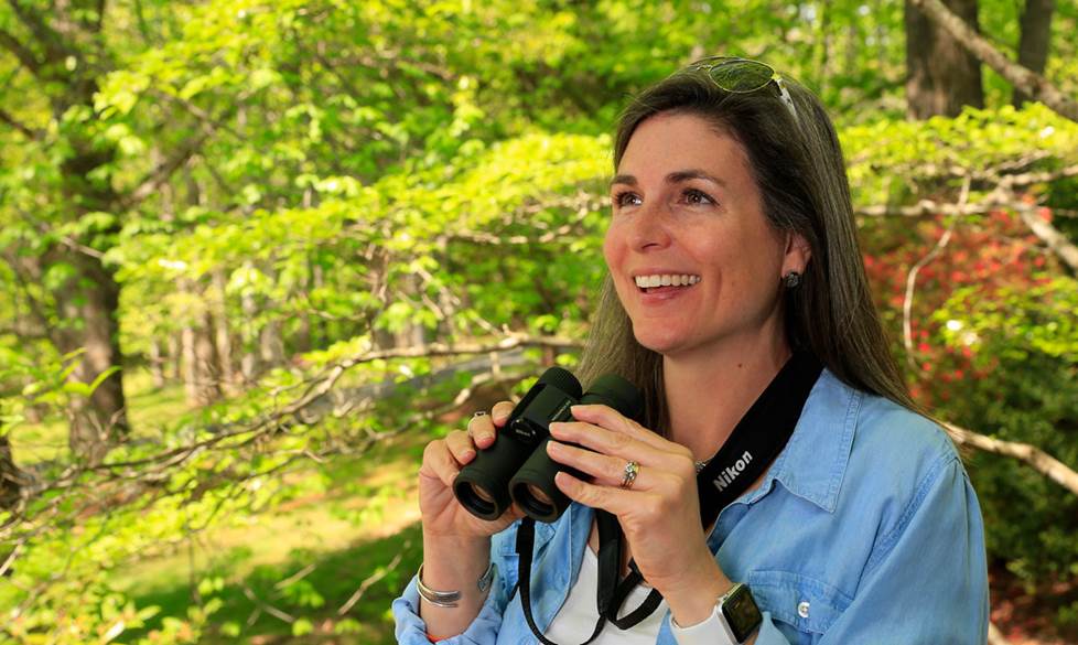 A woman happily enjoying her binoculars.