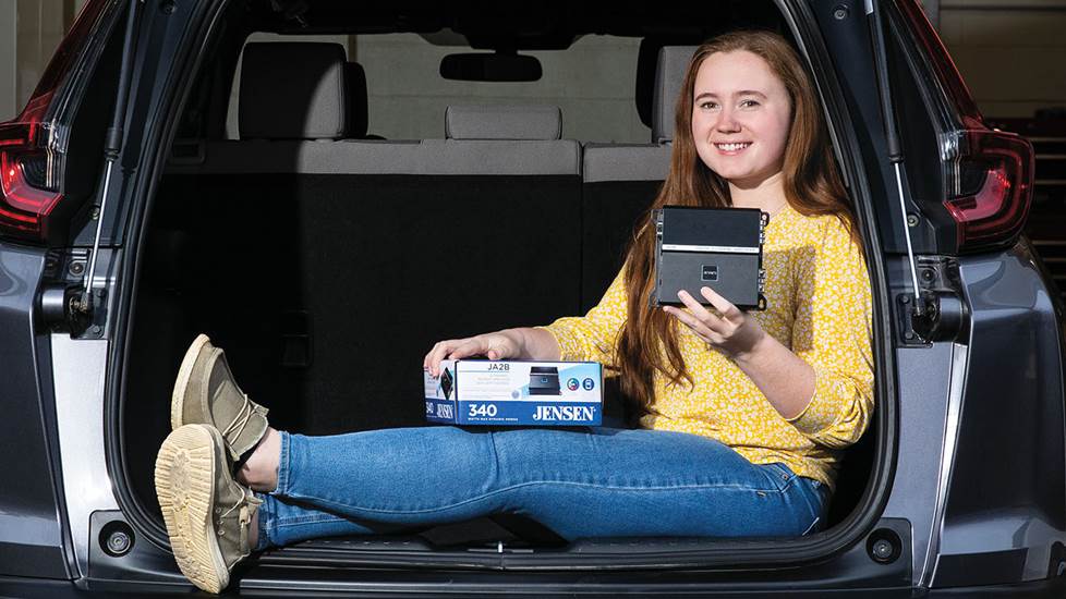 Crutchfield Advisor River in back of car posing with Jensen DSP amps