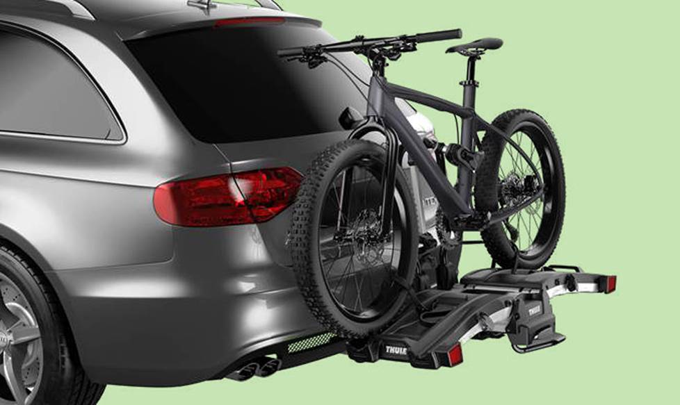 Bike rack on the back of a vehicle, holding a bike.