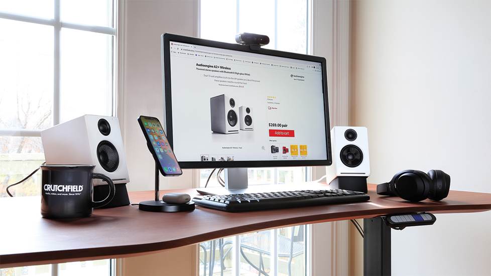 home office desk with speakers and other electronics products