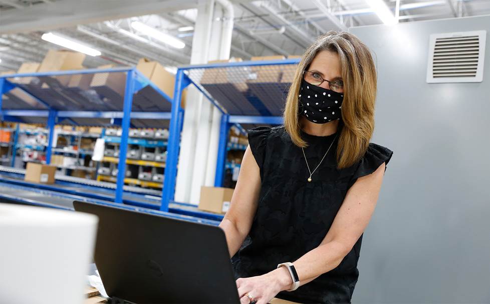 Woman working in a warehouse wearing a face mask