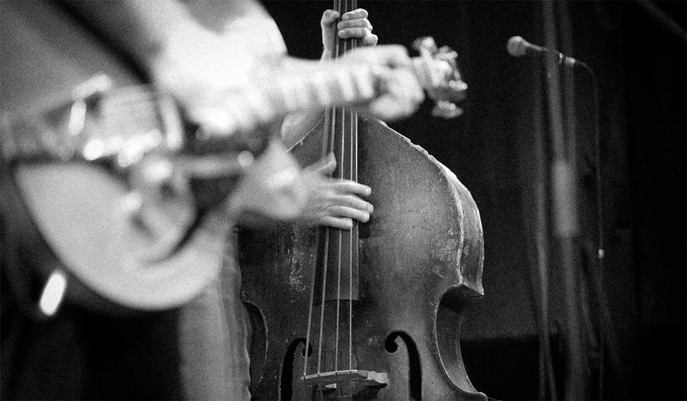 black and white photo of stand up bass player on stage