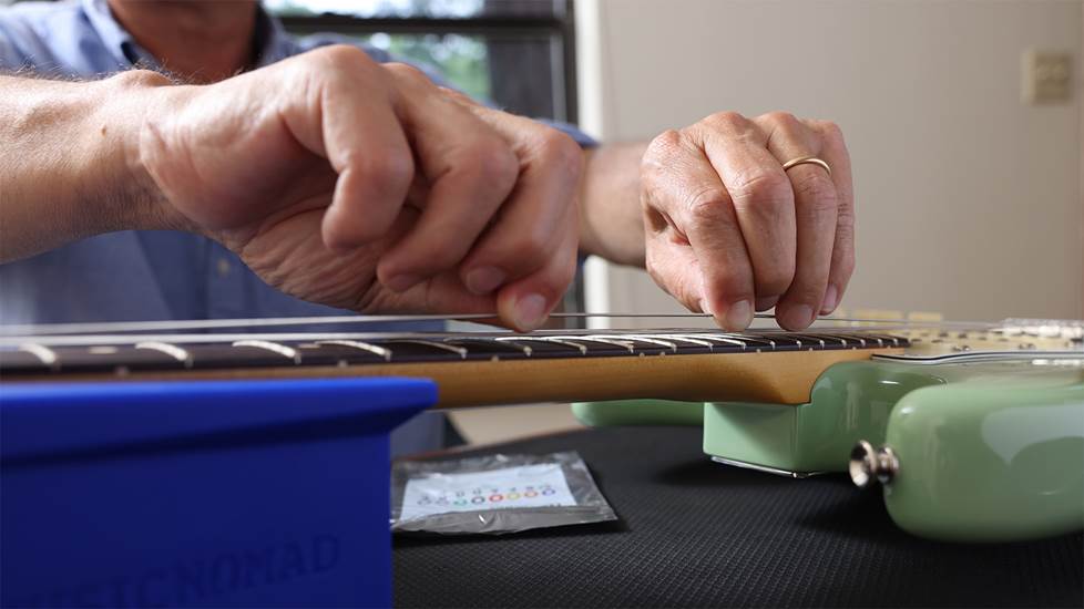 pulling on a guitar string to strech it
