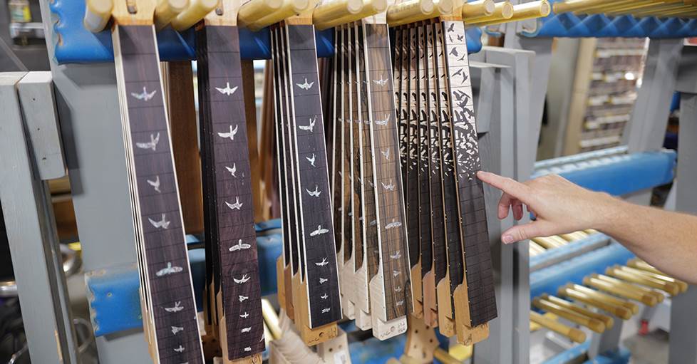 A variety of PRS necks displaying a variety of bird inlays and awaiting frets.