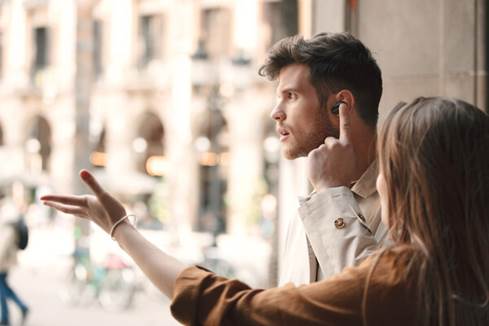 Man placing finger on left earbud